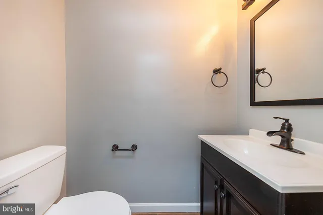a bathroom with a sink a toilet and mirror