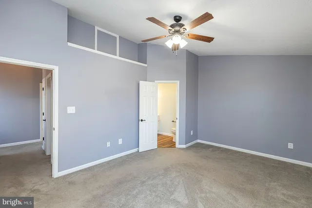 a view of an empty room with a chandelier fan