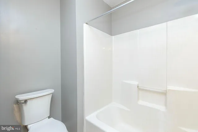 a white toilet sitting next to a white sink