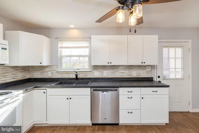 a kitchen with granite countertop a sink cabinets and window