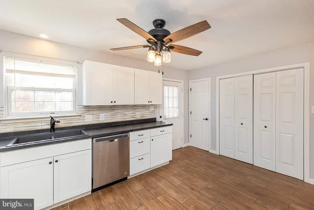 a kitchen with a sink granite counter tops and a large window