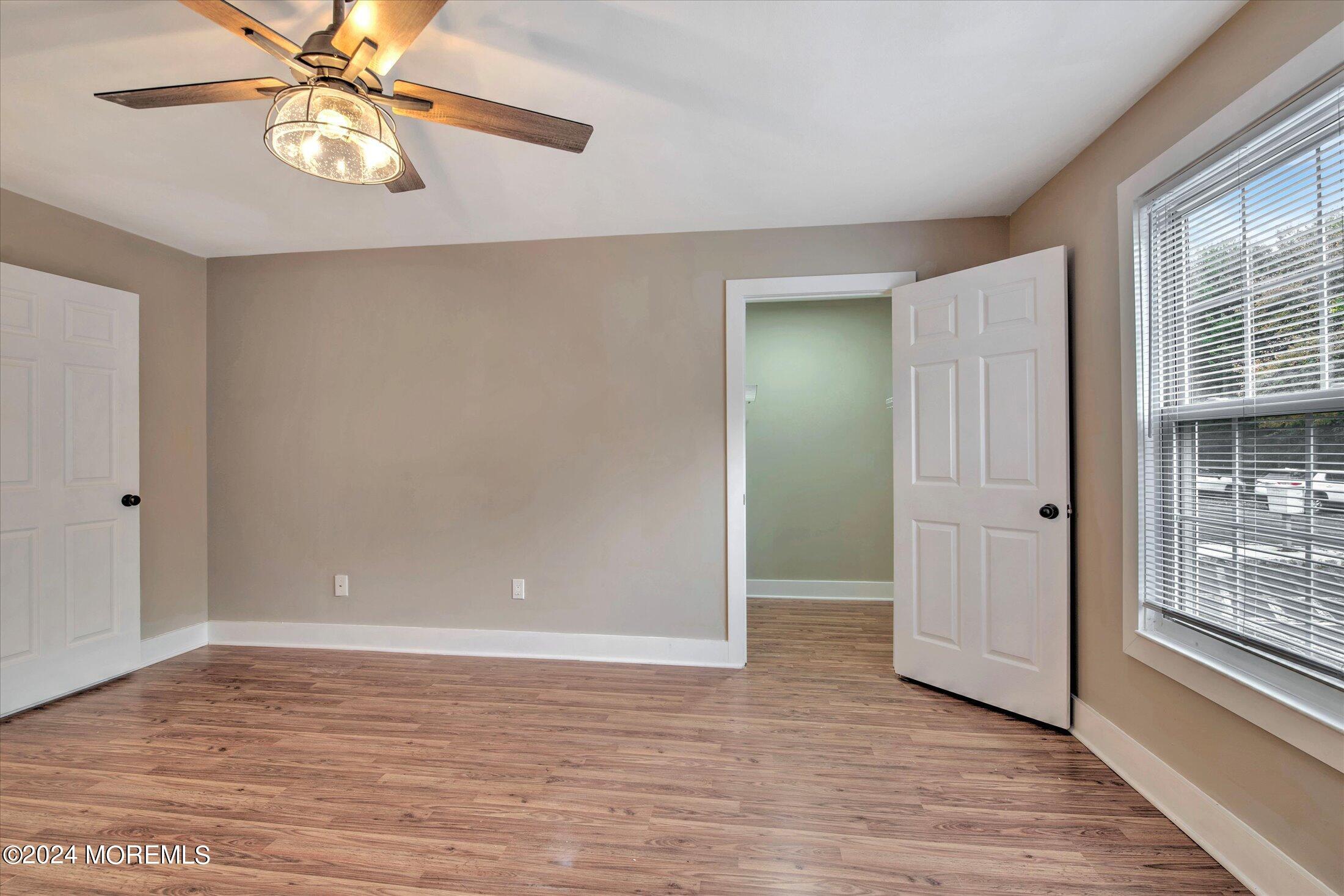 509 Harding Road, Unit 1 Freehold, NJ 07728 - Photo 35 of 43 a view of an empty room with window and wooden floor