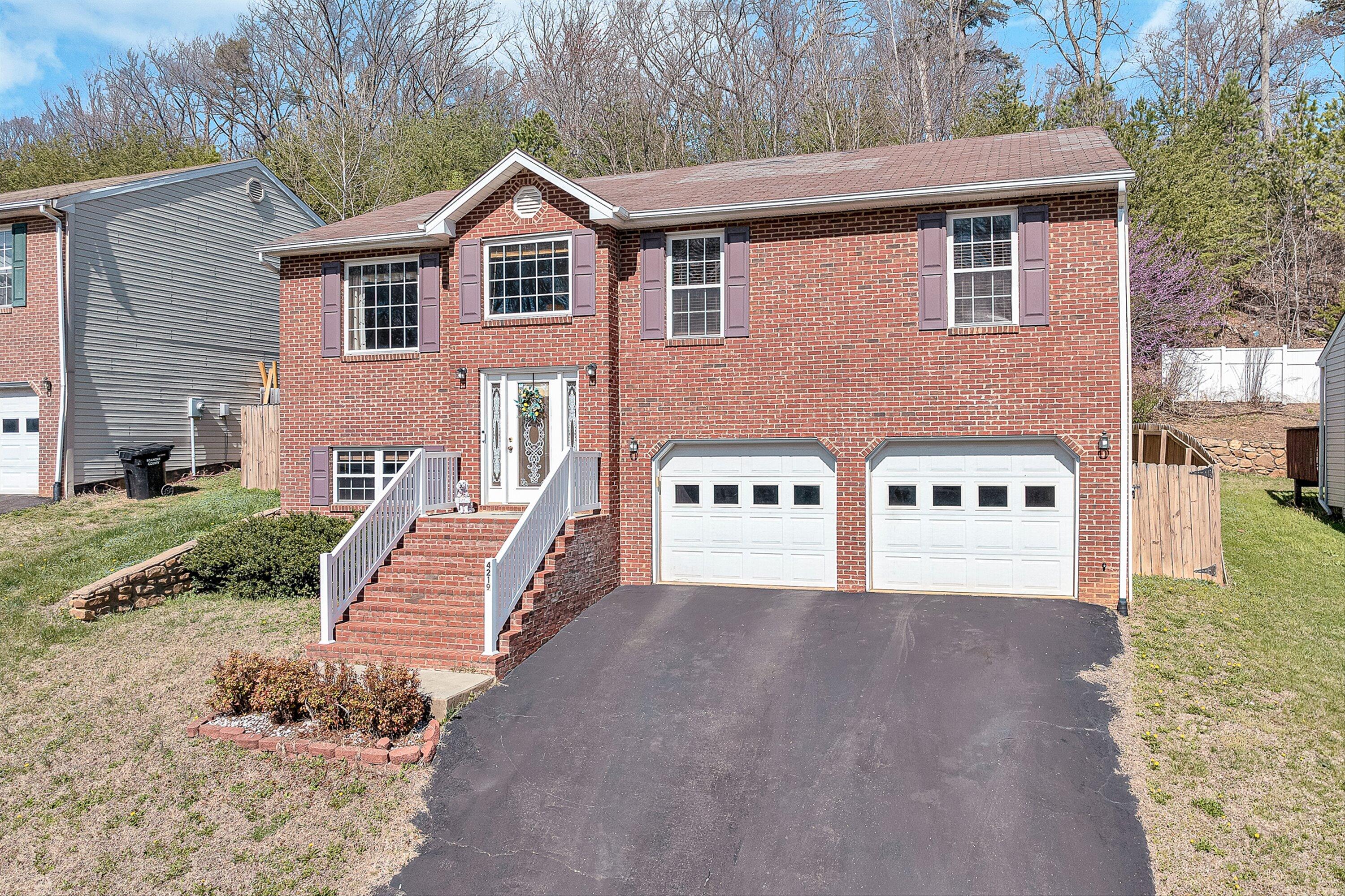 a view of a house with a yard and large trees