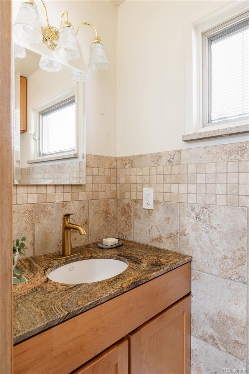 3095 Crabapple Road Golden, CO 80401 - Photo 38 of 50 a bathroom with a granite countertop sink and a mirror