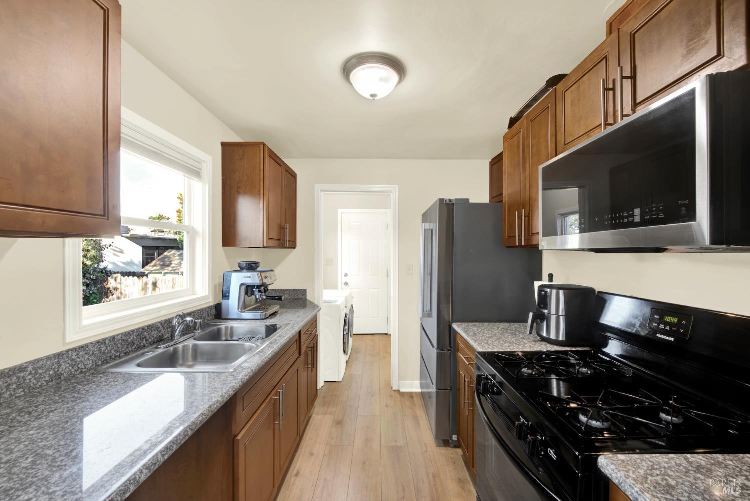 91 14th Street Vallejo, CA 94590 - Photo 18 of 48 a kitchen with stainless steel appliances granite countertop a sink stove microwave and refrigerator