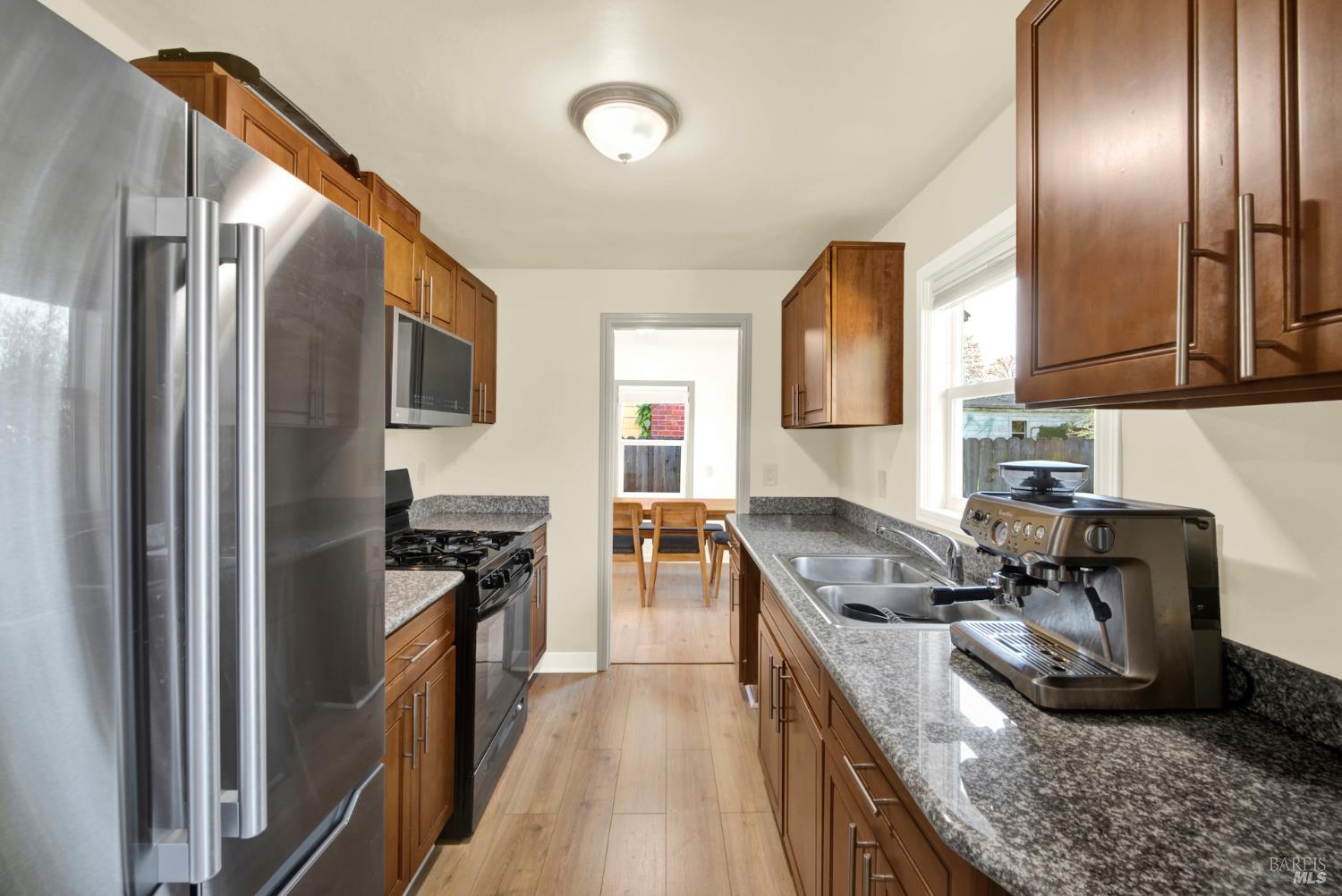 91 14th Street Vallejo, CA 94590 - Photo 23 of 48 a kitchen with stainless steel appliances granite countertop a refrigerator a stove and a sink