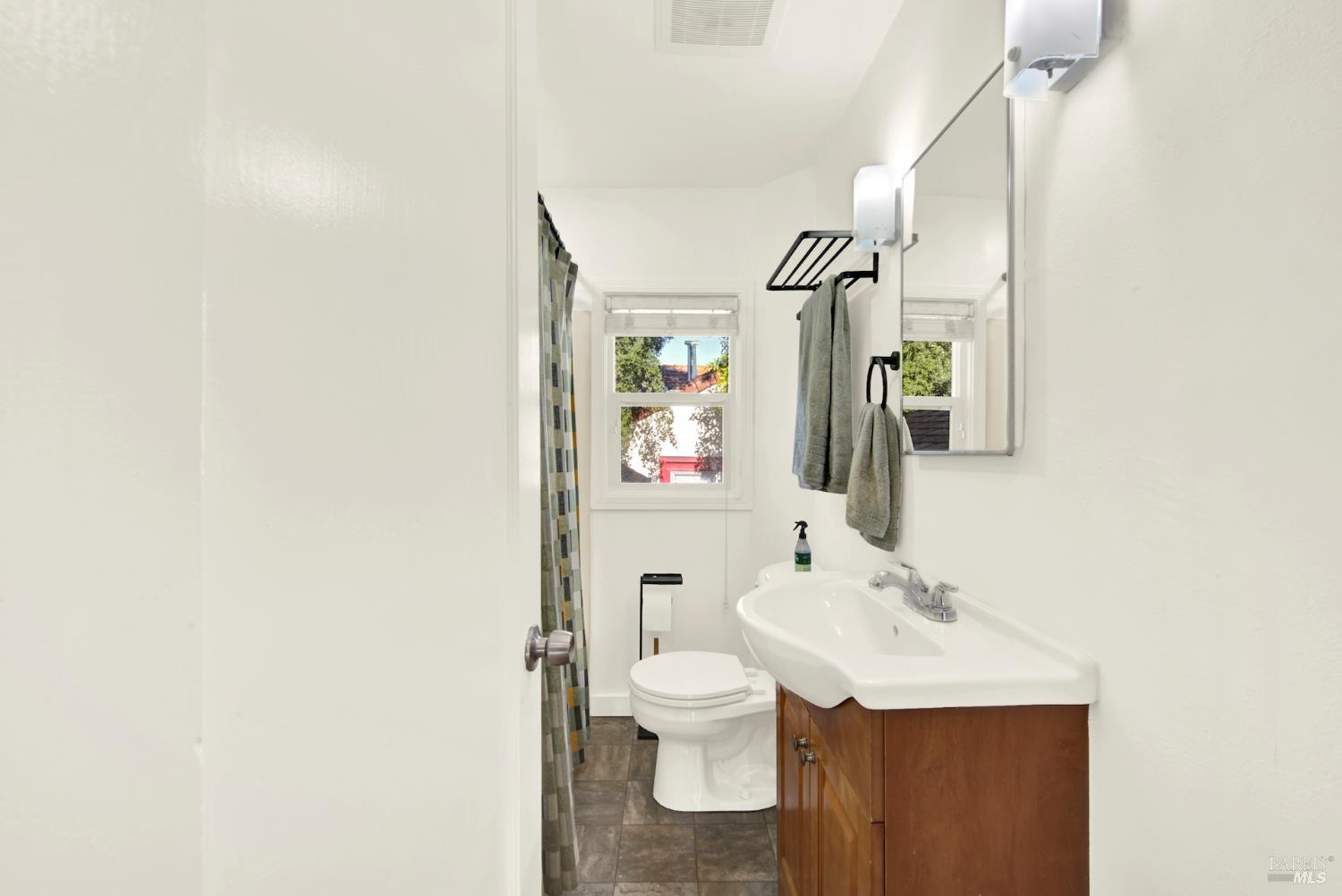 91 14th Street Vallejo, CA 94590 - Photo 30 of 48 a bathroom with a toilet a sink and mirror