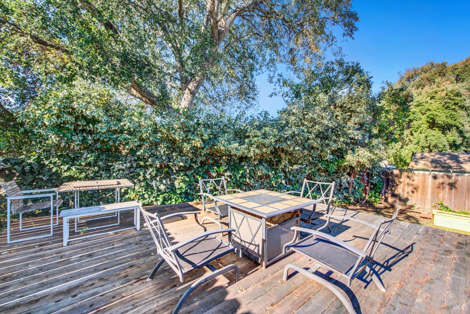 91 14th Street Vallejo, CA 94590 - Photo 39 of 48 a view of a patio with table and chairs with wooden floor and fence