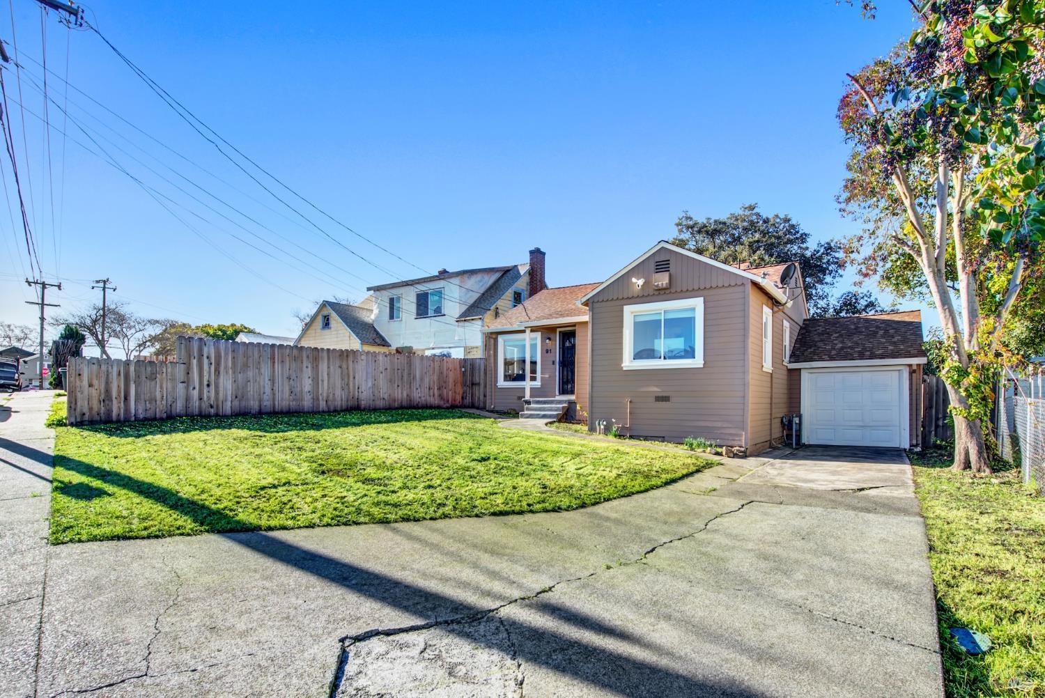 91 14th Street Vallejo, CA 94590 - Photo 4 of 48 a front view of a house with a yard and garage