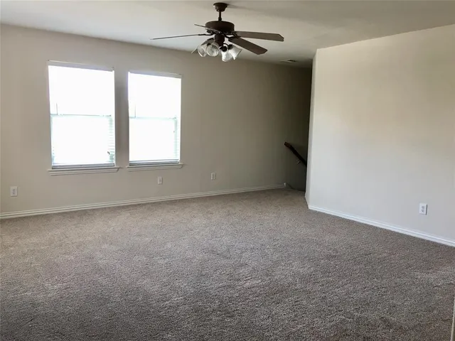 an empty room with a window and a ceiling fan