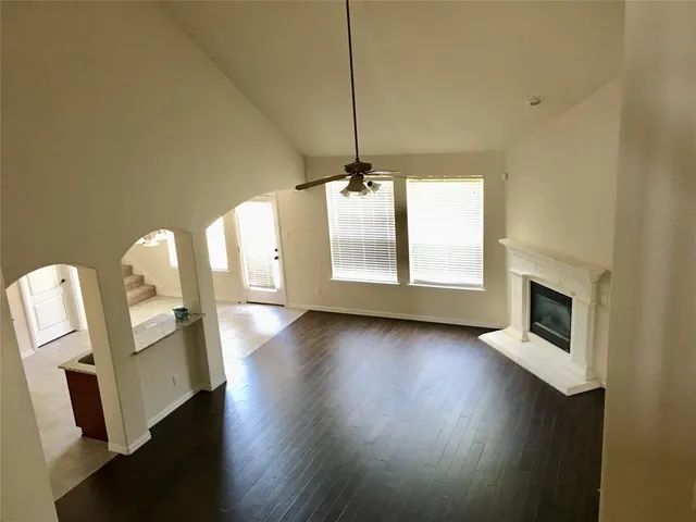 a view of a livingroom with wooden floor and a fireplace