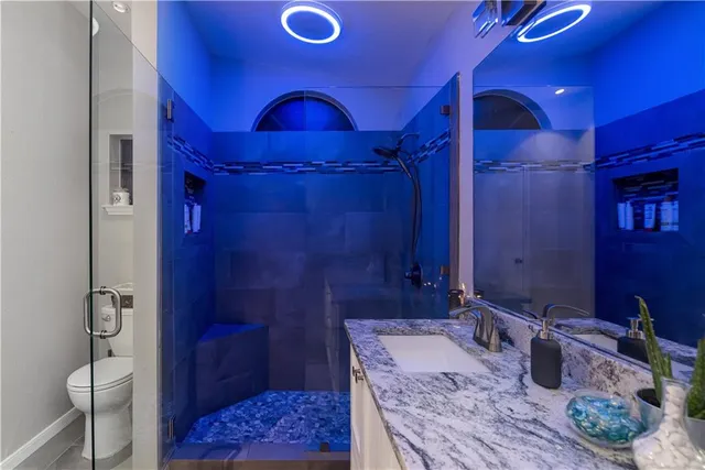 a bathroom with a double vanity sink toilet and shower