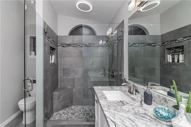 a bathroom with a granite countertop shower and a sink