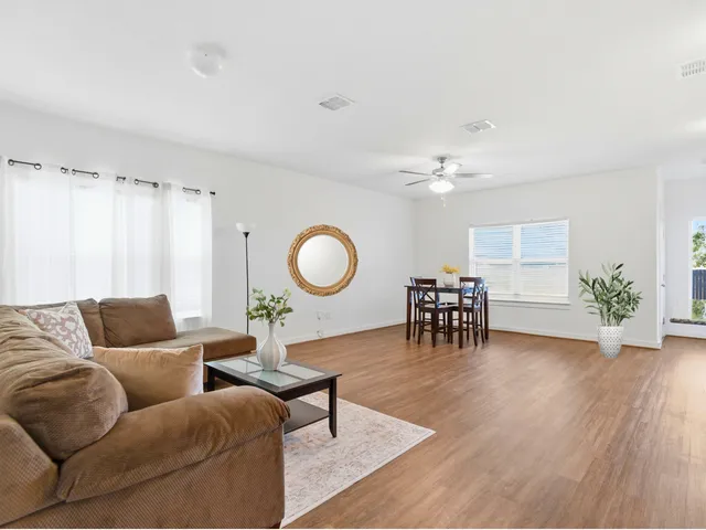 a living room with furniture and a wooden floor