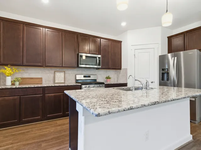 a kitchen with stainless steel appliances granite countertop a sink stove and refrigerator