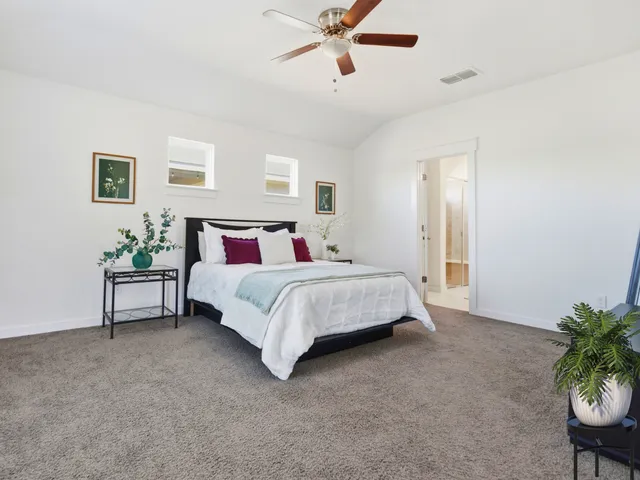 a bedroom with a bed and a potted plant