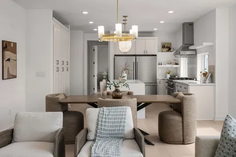 a dining room with furniture and kitchen view