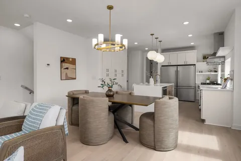 a kitchen with stainless steel appliances granite countertop a sink a stove a refrigerator and a refrigerator