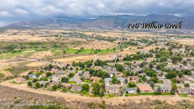 a view of a dining room and livingroom with furniture wooden floor a chandelier