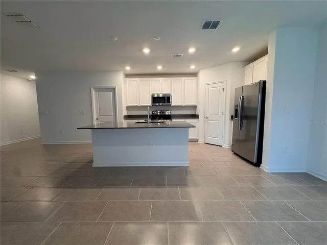 a kitchen with stainless steel appliances granite countertop a refrigerator and a stove top oven