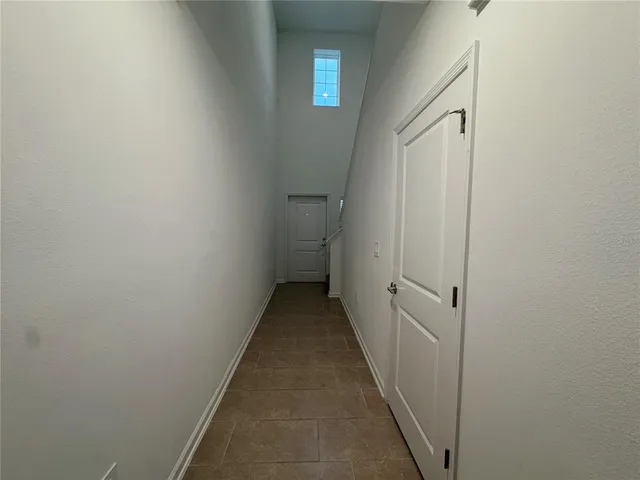 a view of a hallway with wooden floor and closet