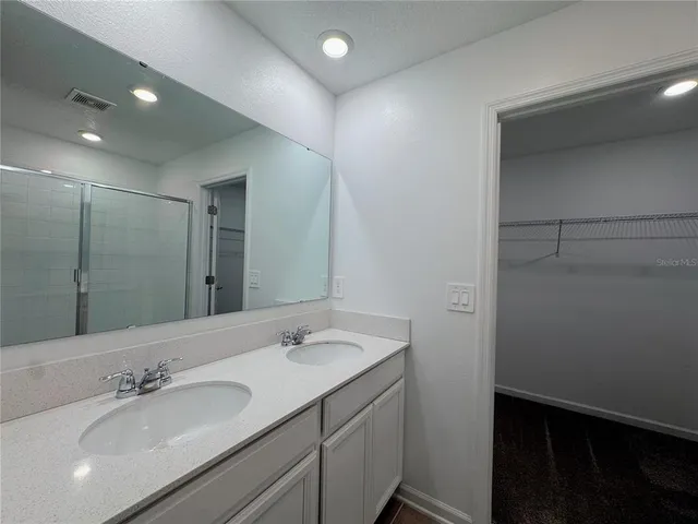 a bathroom with a double vanity sink and a mirror