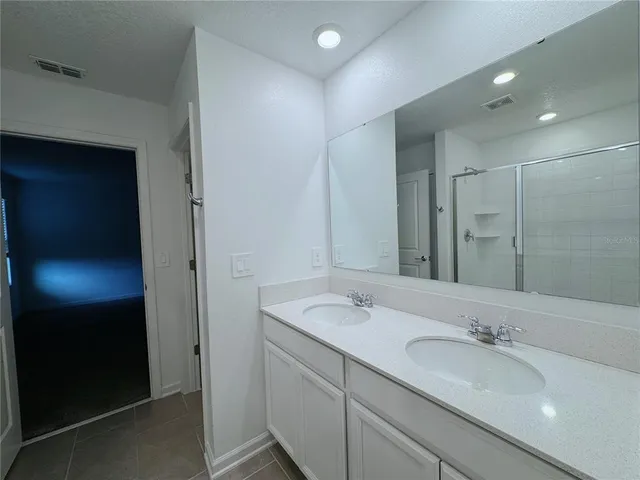 a bathroom with a double vanity sink and a mirror
