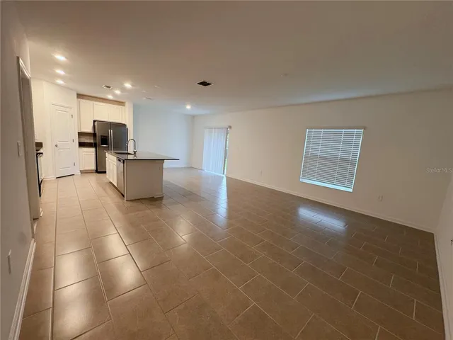 a view of a living room hardwood floor and a kitchen