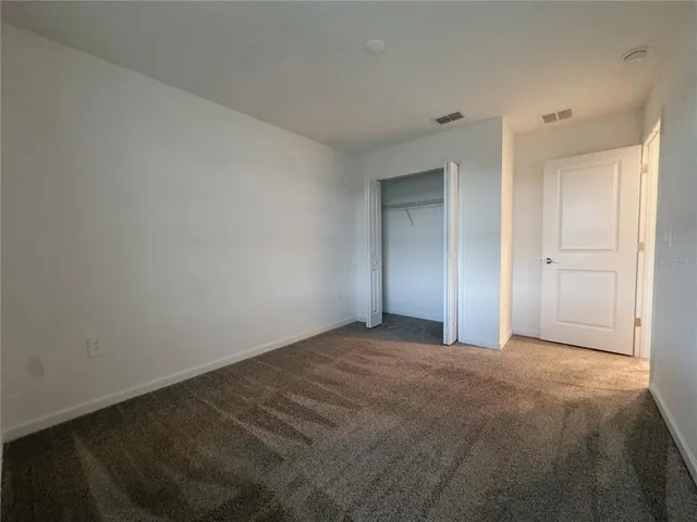a view of an empty room and closet area
