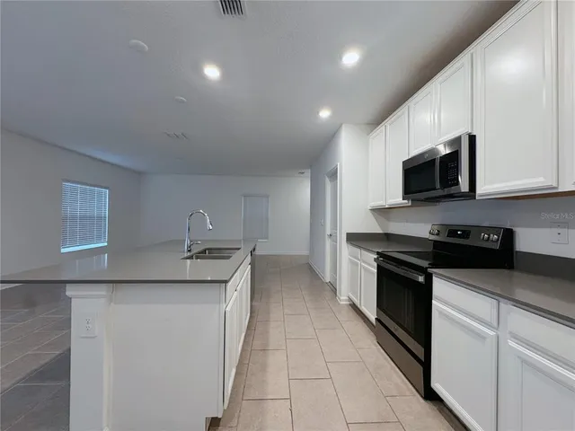 a kitchen with stainless steel appliances granite countertop a sink and a stove