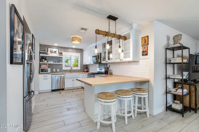 a kitchen with a table chairs refrigerator and cabinets