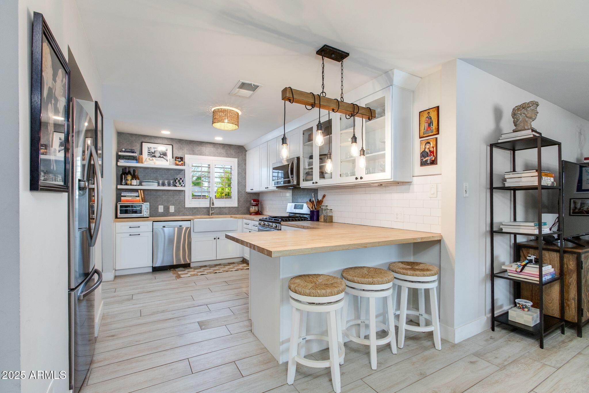 913 West Missouri Avenue Phoenix, AZ 85013 - Photo 14 of 38 a kitchen with a table chairs refrigerator and cabinets
