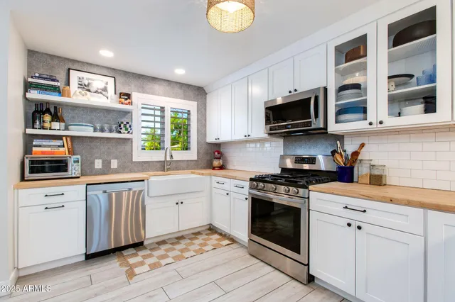 a kitchen with stainless steel appliances granite countertop a stove sink microwave and cabinets
