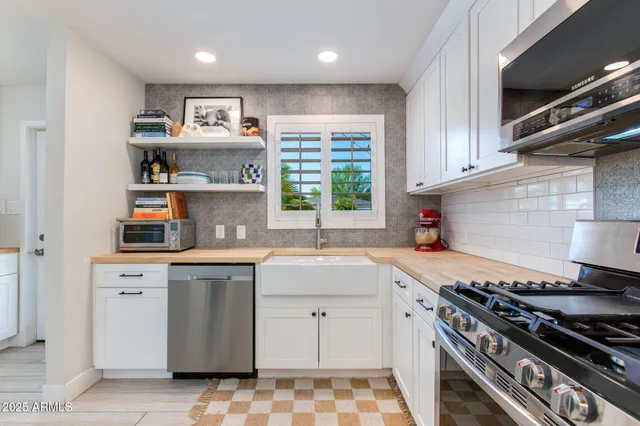 a kitchen with granite countertop a stove sink and cabinets