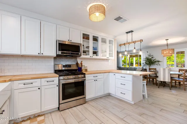 a kitchen with cabinets stainless steel appliances a stove and a window