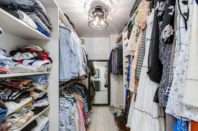 a view of walk in closet with clothes and shoes