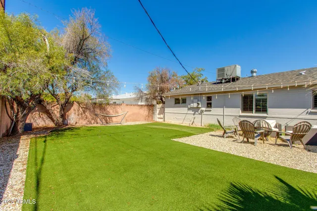 a view of a house with backyard and sitting area
