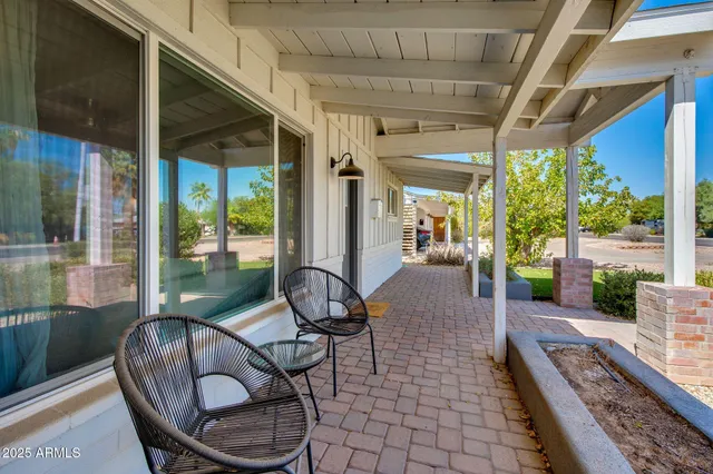 a living room with patio furniture and a floor to ceiling window
