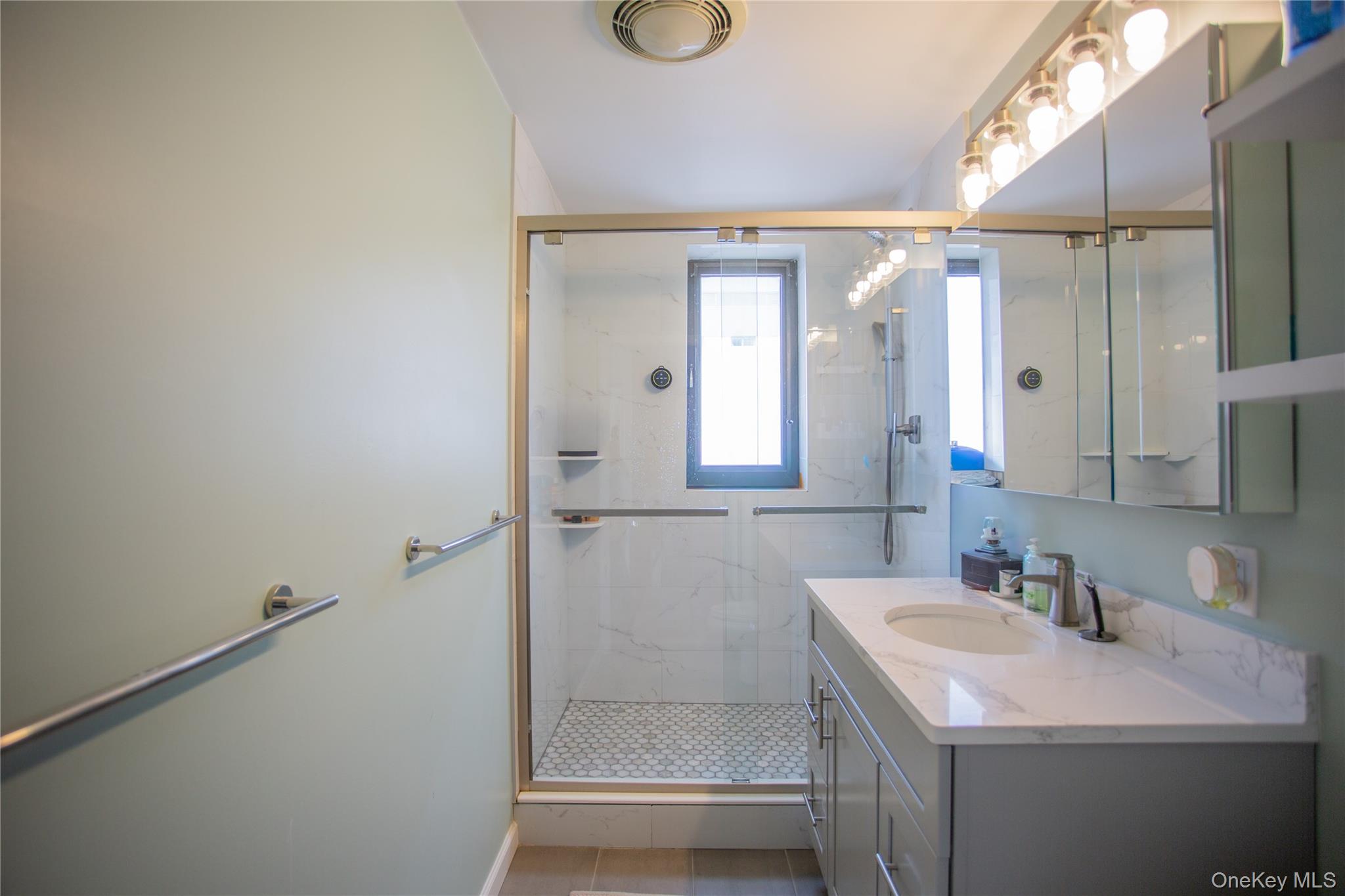100 West Broadway, Unit 3D Long Beach, NY 11561 - Photo 15 of 50 a bathroom with a granite countertop sink and a mirror