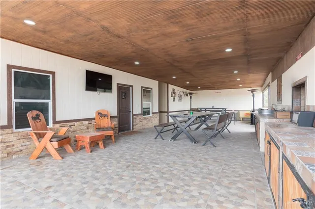 a living room with furniture a flat screen tv and kitchen view