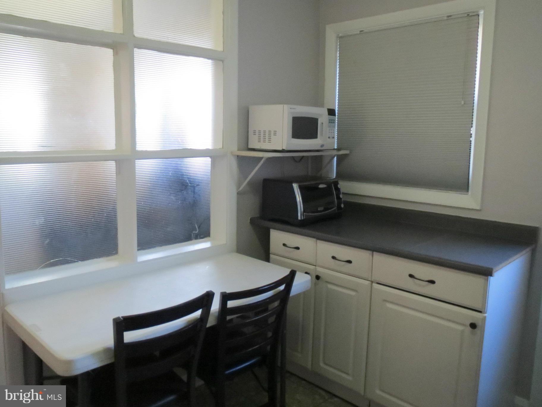 7006 Boxford Road Baltimore, MD 21215 - Photo 7 of 14 a kitchen with a table chairs and a window
