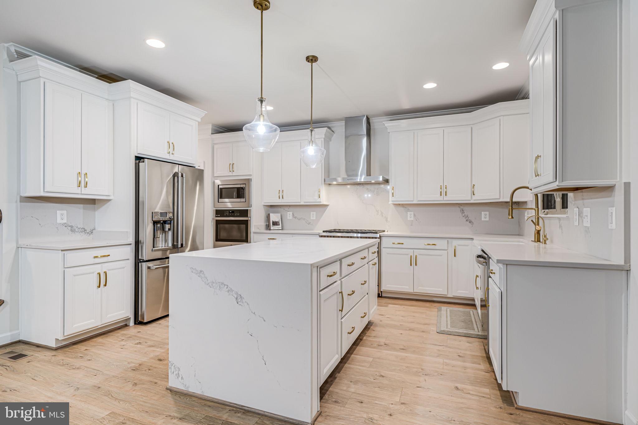 7917 Turtle Creek Circle Gainesville, VA 20155 - Photo 22 of 41 a kitchen with kitchen island white cabinets and stainless steel appliances