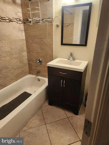a bathroom with a sink vanity mirror bathtub shower and toilet