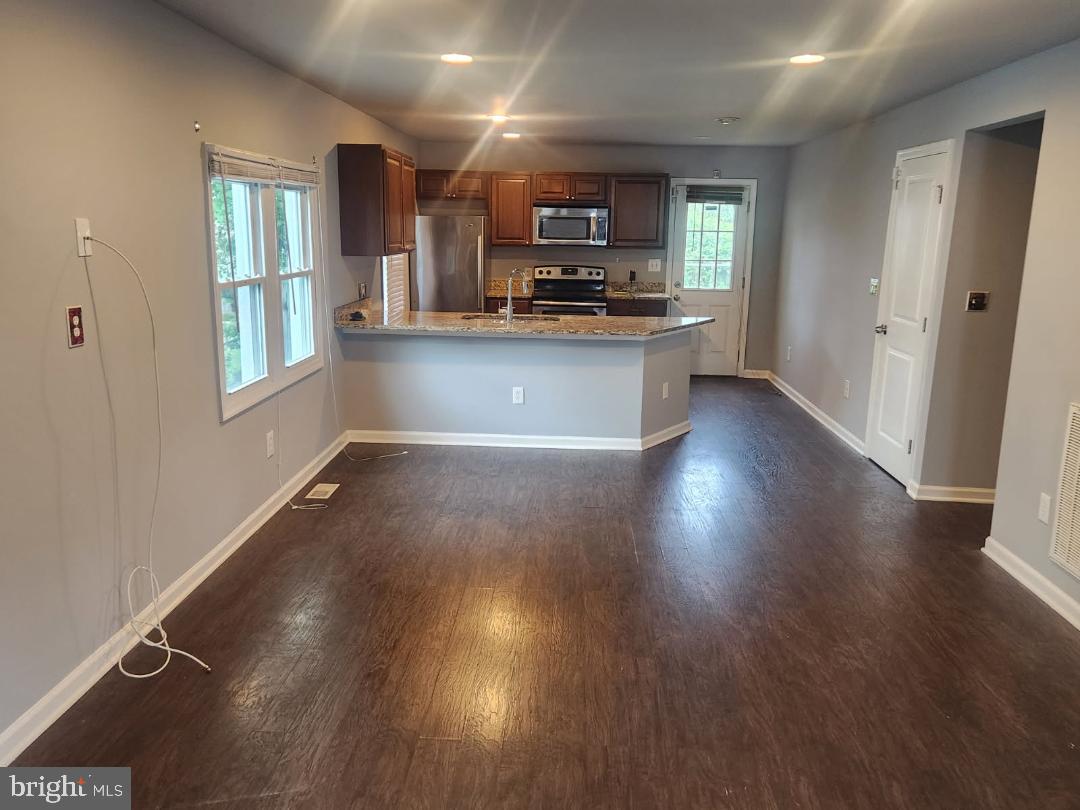 1011 Nova Avenue Capitol Heights, MD 20743 - Photo 3 of 15 a kitchen with stainless steel appliances granite countertop a stove a sink dishwasher and a microwave oven on the wooden floor