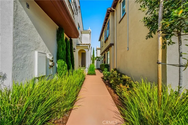 a view of a pathway both side of flower in front of a building