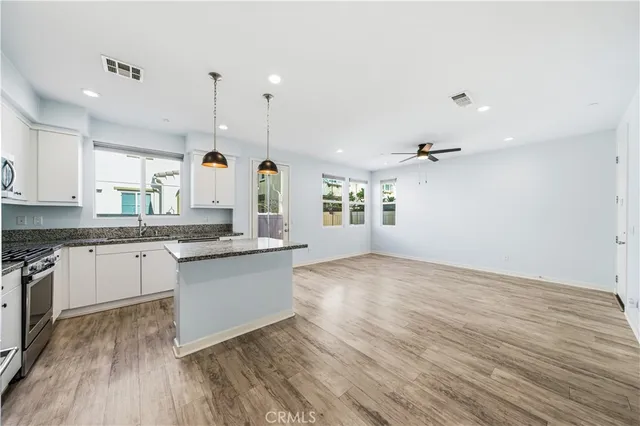 a large kitchen with cabinets wooden floor and stainless steel appliances
