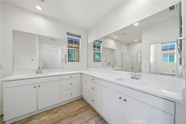 a spacious bathroom with double sink and mirror