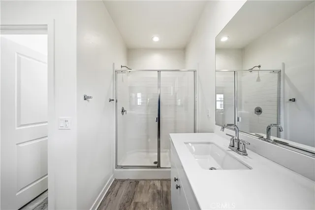 a bathroom with a sink a toilet a large mirror and shower