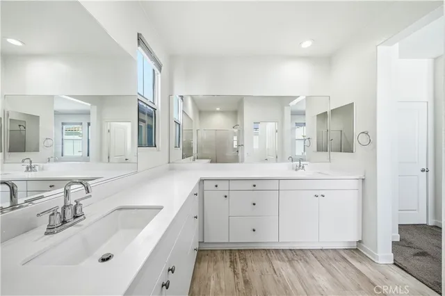 a spacious bathroom with a double vanity sink a mirror and a bathtub