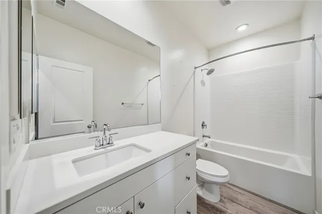 a bathroom with a sink toilet vanity and shower
